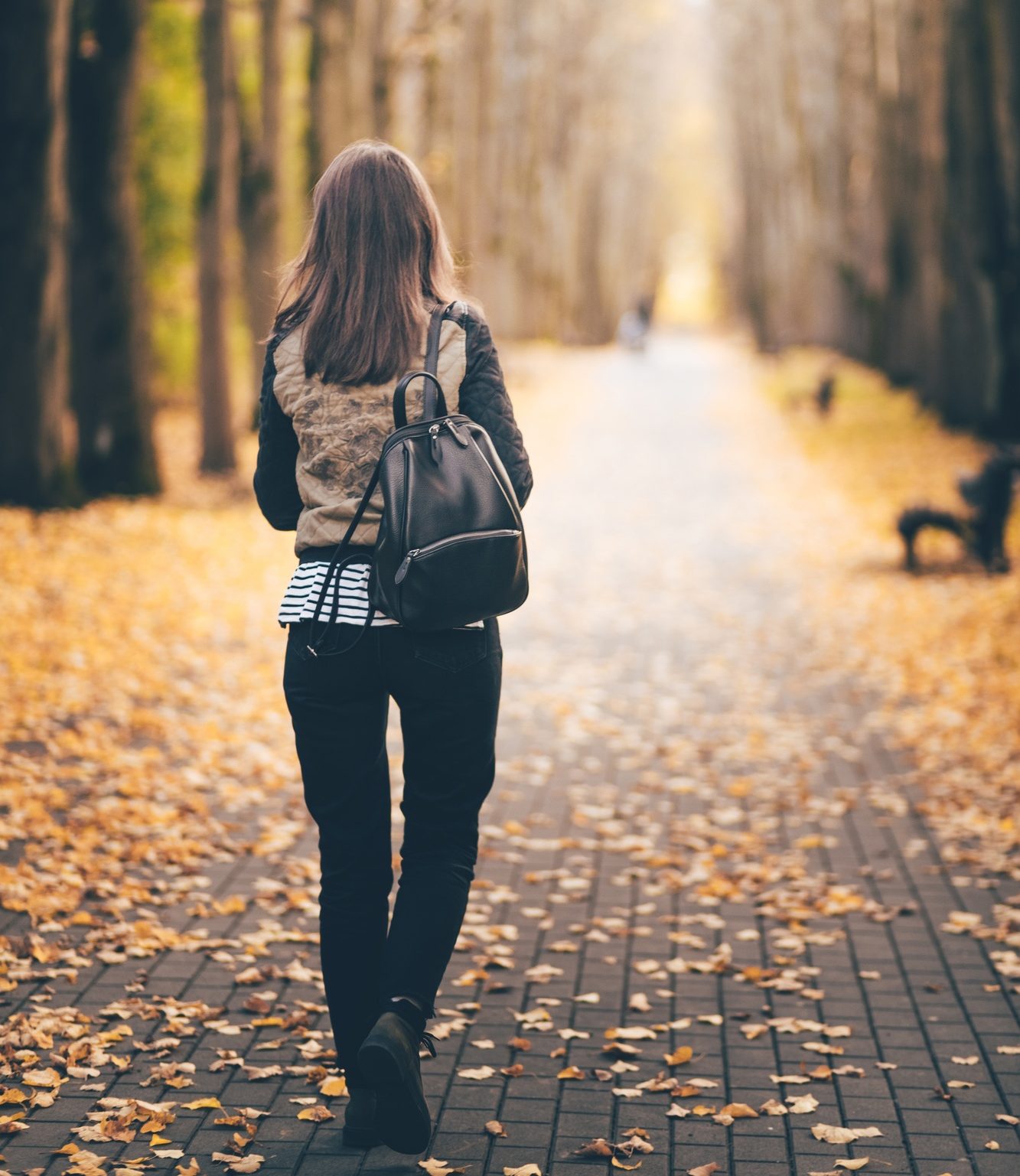 Young woman walk on the road in park .